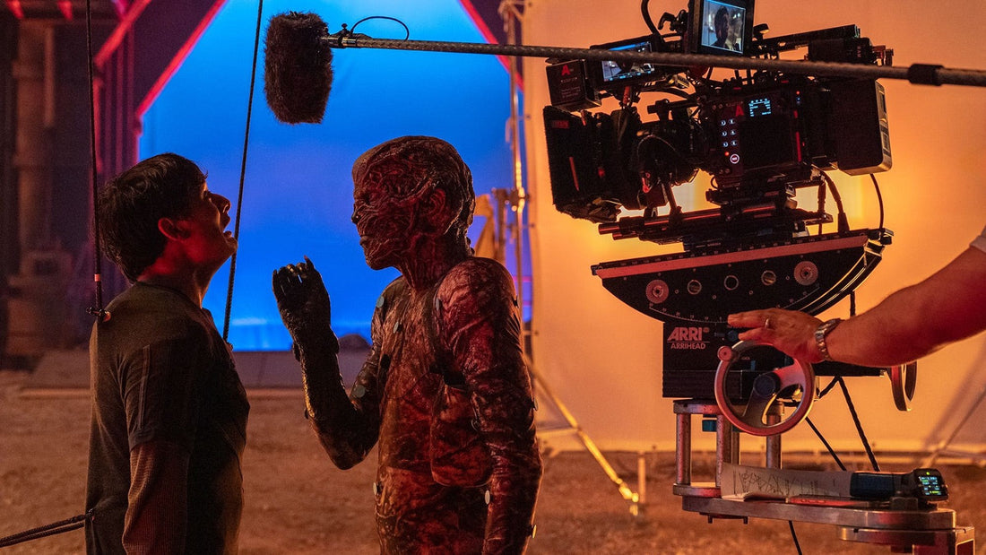 Opnames van Stranger Things: camera, geluidshengel en blauw doek tegenover een als wezen geschminkte acteur