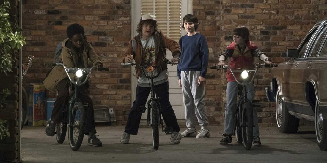 Drie kinderen op de fiets rond een jongen in blauwe sweater: wie is het hoofdpersonage van Stranger Things?