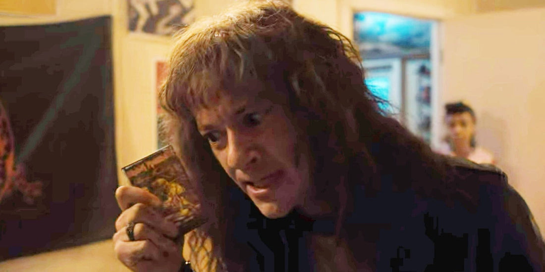 Eddie Munson houdt een cassette van Iron Maiden, Piece of Mind, omhoog in zijn kamer