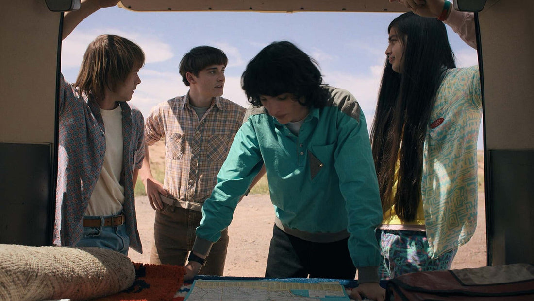 Vier tieners gebogen over een kaart, achter in een busje, Stranger Things seizoen 4 aflevering 5
